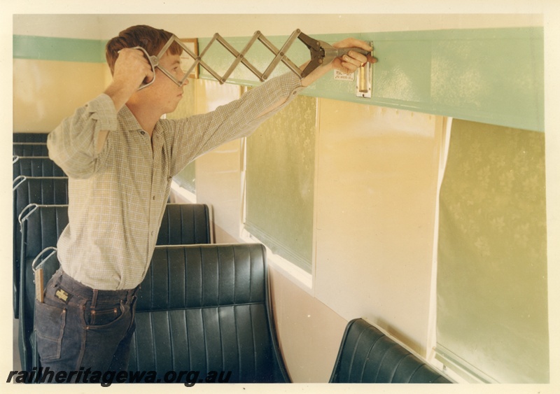 P16082
An apprentice worker fixing an item to the panelling in a ADA class railcar trailer, Midland Workshops.
