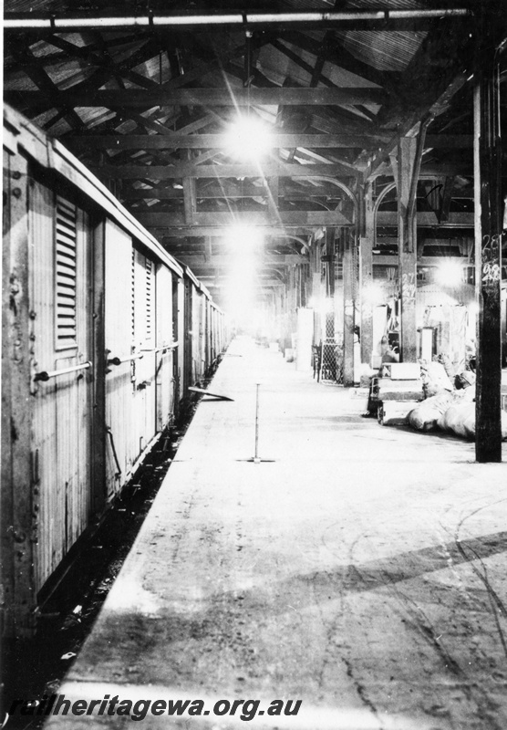 P16094
A rake of covered vans being loaded/unloaded in goods shed at an Unknown location.
