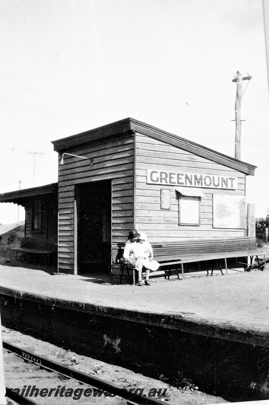 P16116
Passenger waiting shed and station building as depicted in 1928. Greenmount, M line, the platform seat needs a few repairs to be done. Also of note is the unshaded electric light over the door to the waiting shed.
