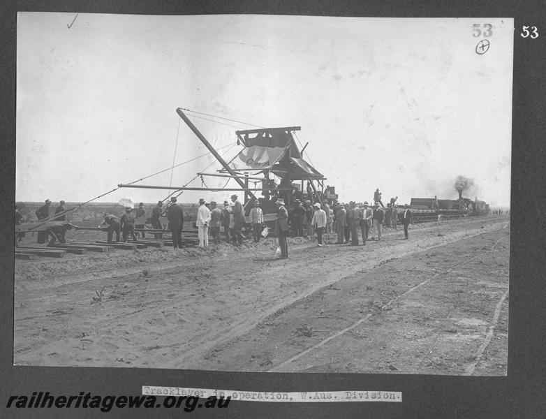 P16170
Commonwealth Railways (CR), Roberts tracklaying machine in operation, workers, steam loco, Western Australian Division, construction of TAR line, c1916
