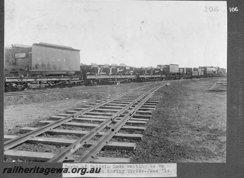 P16172
Commonwealth Railways (CR), rake of flat bed wagons including number 4454, laden with parts of G class steam locos, awaiting unloading during construction strike, Kalgoorlie, TAR line, end and side view
