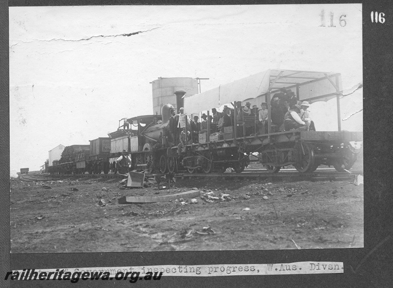 P16174
Commonwealth Railways (CR), Q class steam loco, later reclassified D class, on progress of construction inspection train including flat bed wagon with canopy and seats for government guests, water tower, Western Australian Division, TAR line, side and end view
