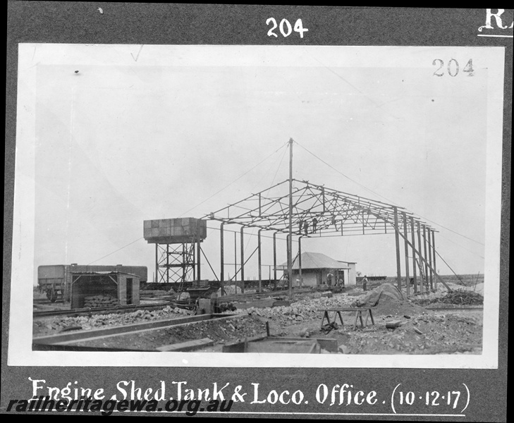 P16178
Commonwealth Railways (CR), water tower, loco office, engine shed under construction, workers, wagon, construction of TAR line
