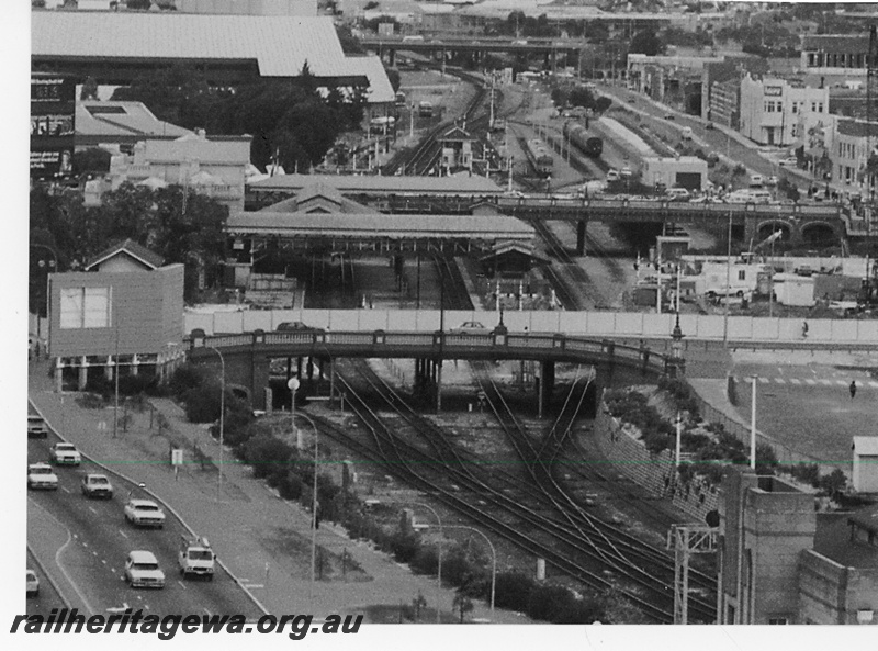 P16215
Overview of Perth City station, Barrack Street bridge (foreground), platforms, signals, bracket signals, Horseshoe bridge, signal box B, freeway bridge across tracks (background), view looking west from 7th floor Royal Perth hospital
