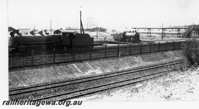 P16226
P class loco, another steam loco on turntable, double tracks in foreground, fence, overhead footbridge and stairs, East Perth loco depot, ER line
