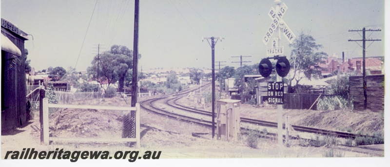 P16256
Main line running through town centre behind Fitzgerald street shops, level crossing, Northam, ER line, view looking west towards station 
