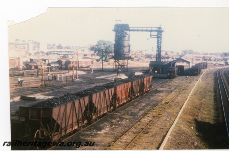 P16281
The coal loading tower at East Perth locomotive depot with the wagon unloading shed in the middle. A rake of loaded XA class coal wagons are waiting to ne unloaded.
