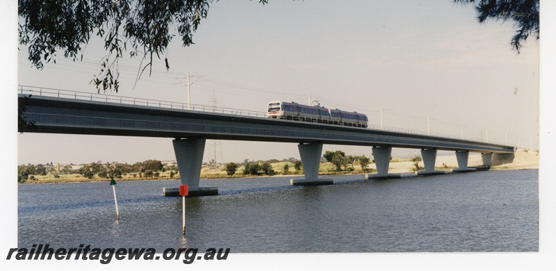 P16342
EMU two railcar set, crossing Swan River on concrete and steel Goongoongup bridge, East Perth, SWR line, front and side view, c1995
