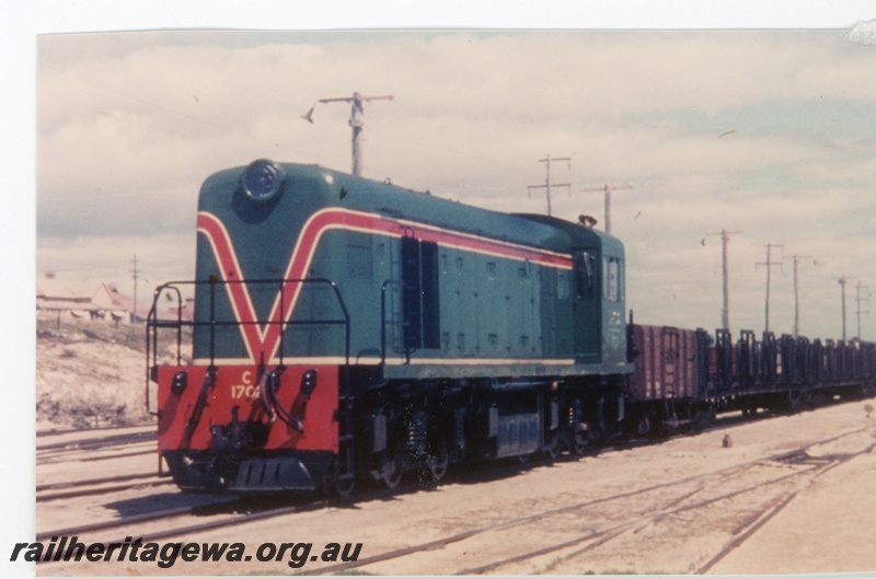 P16347
C class 1702, in green with red and yellow stripe, on goods train, front and side view, Leighton Yard
