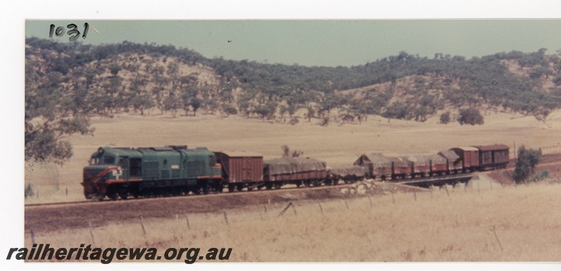P16373
X class loco in green with red and yellow stripe livery, on goods train, crossing culvert, near Toodyay, CM line, front and side view 
