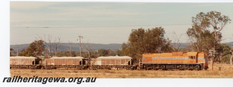 P16386
AA class 1519, in Westrail orange with blue and white stripe livery, on ballast train comprising XM class wagons, rural setting, side on view
