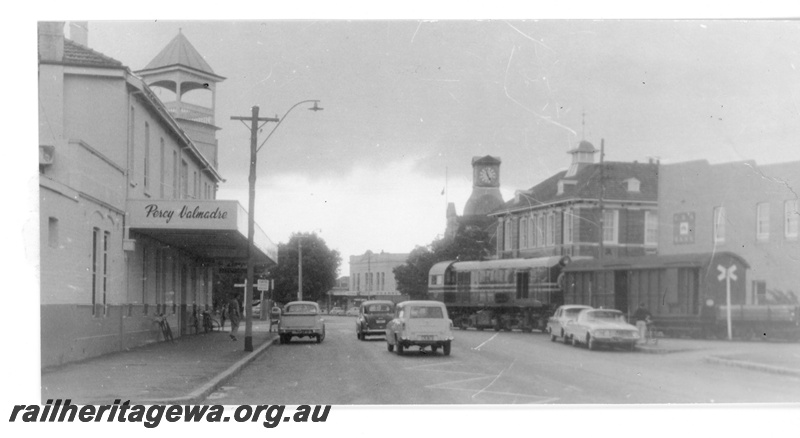 P16397
MRWA F class diesel, hauling van and wagon, crossing Great Eastern Hwy, Midland, view looking west
