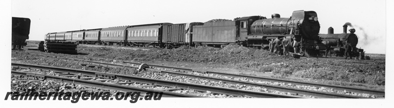 P16456
Commonwealth Railways (CR) C class 63, stopped on passenger train, sleeper pile, scotch block, workers, TAR line
