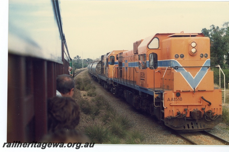 P16500
AA class 1518 with another diesel, both in Westrail orange with blue and white stripe, on goods train, view from passing excursion train
