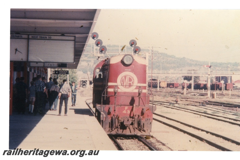 P16533
Ex MRWA F class 43, in maroon livery, platform, passengers, canopy, light signals, signal, footbridge, yards, Midland Junction, MR line, front on view, c1964 
