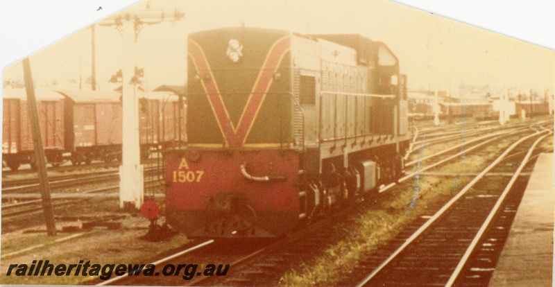 P16538
A class 1507 in green with red and yellow stripe, various wagons, signal, point lever, Perth station, end and side view
