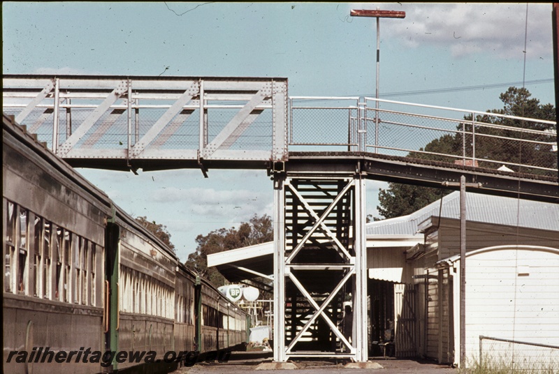 P16668
Pedestrian footbridge, station building, train standing at station, view along platform, Collie, BN line
