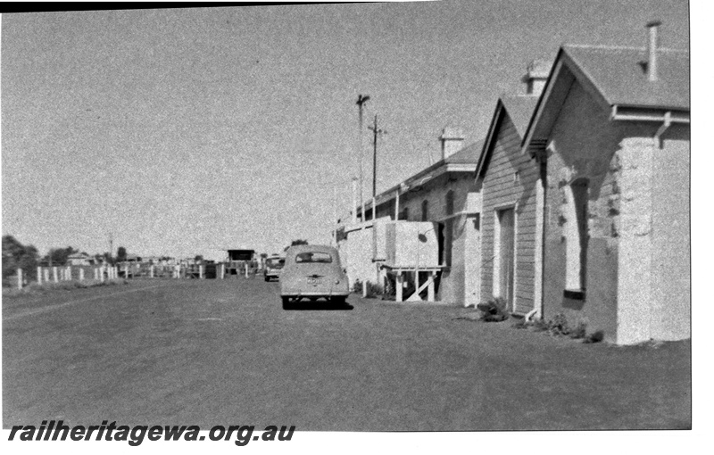 P16710
Front of station buildings, road, car park, cars, Mount Magnet, NR line
