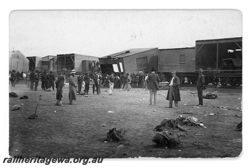 P16804
Commonwealth Railways (CR) - TAR line loading workers camp buildings onto flat wagons. Unknown location. c1916
