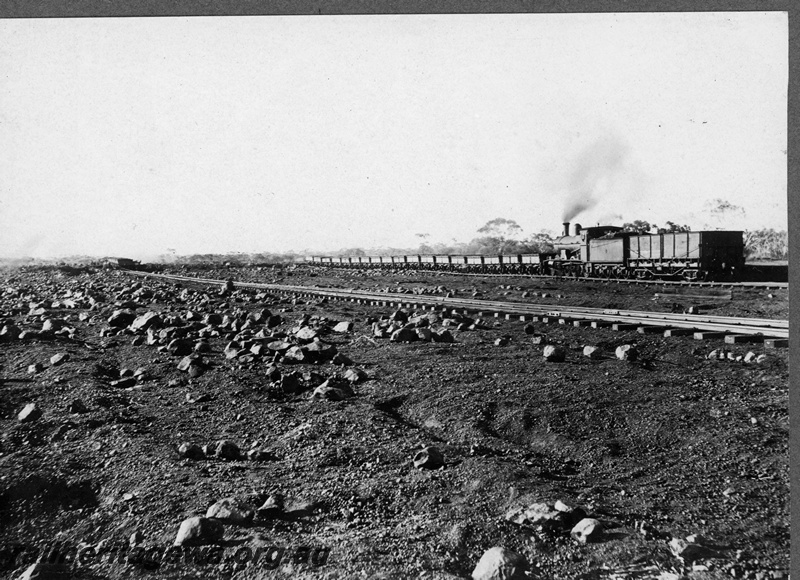 P16836
Commonwealth Railways (CR) - TAR line G class steam locomotive hauling ballast train at an Unknown location. C1916
