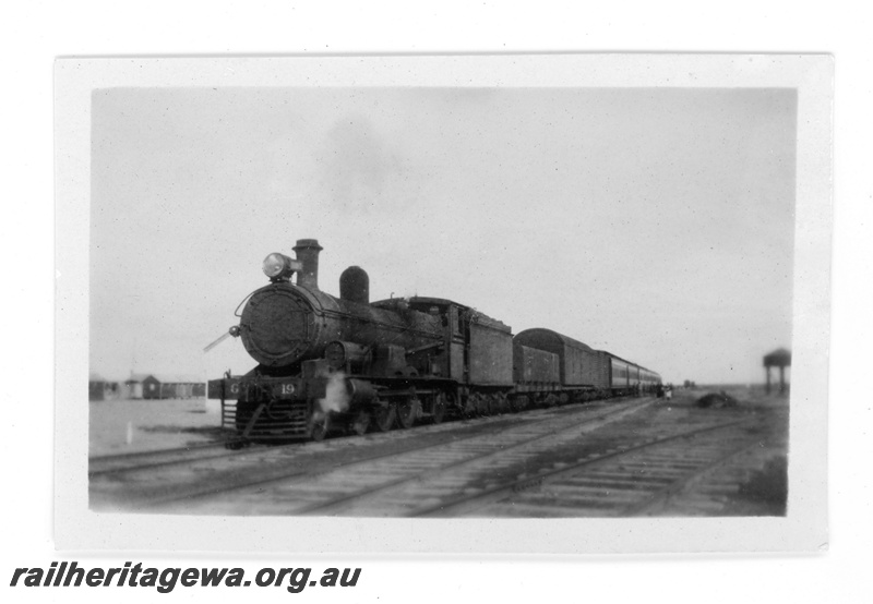 P16861
Commonwealth Railways (CR) - TAR line G class 19 steam locomotive hauling Transcontinental express at an Unknown location. 
