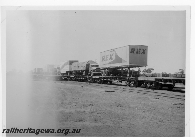 P16872
Commonwealth Railways (CR) - TAR line piggyback trucks on RG class wagon at Parkeston. 
