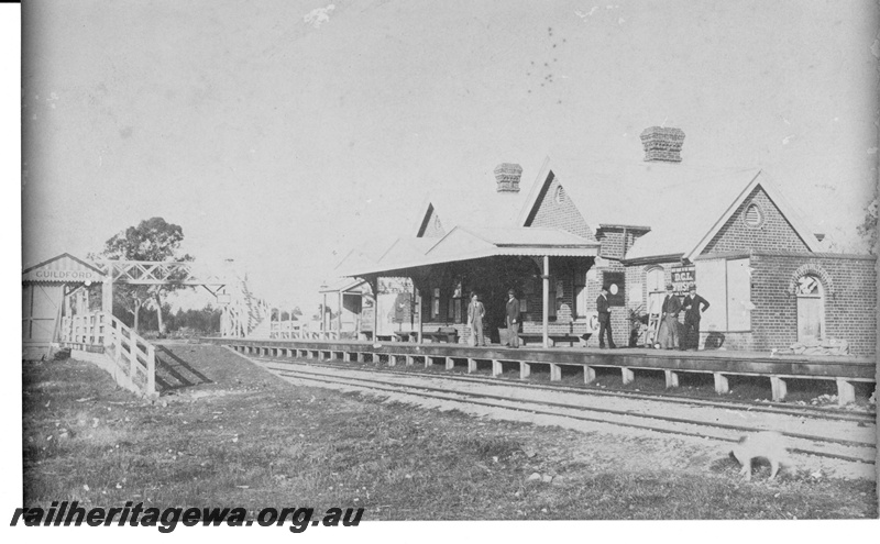 P16960
First Guildford railway station, platforms, station buildings, overhead footbridge, passengers waiting, Guildford, ER line, built 1884 for 1259 pounds 9 shillings by Philip Reilly 
