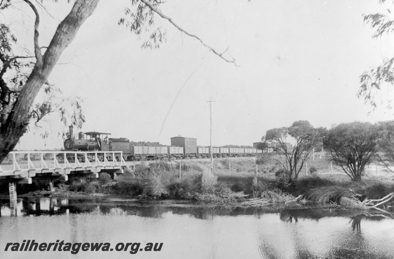 P16962
A class loco with 6 wheeled tender, on goods train, crossing wooden bridge over Vasse River, near Bunbury, SWR line
