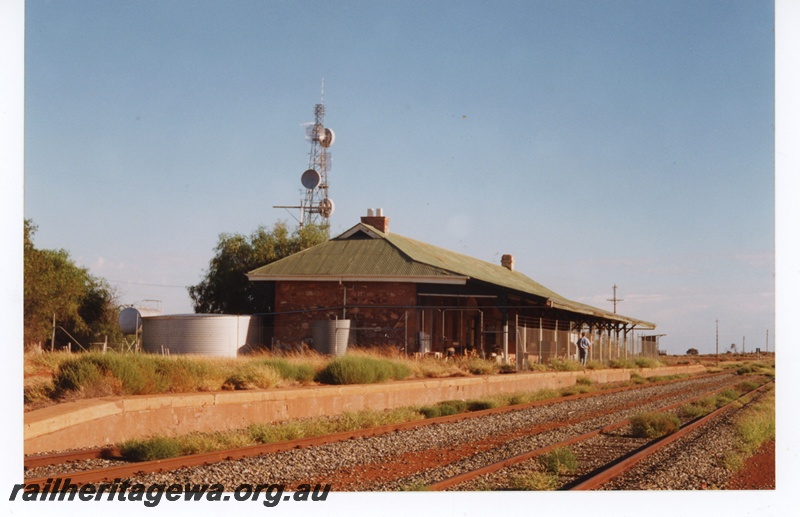 P16995
Station building, fenced off platform, tracks, electronics tower, Menzies, KL line 
