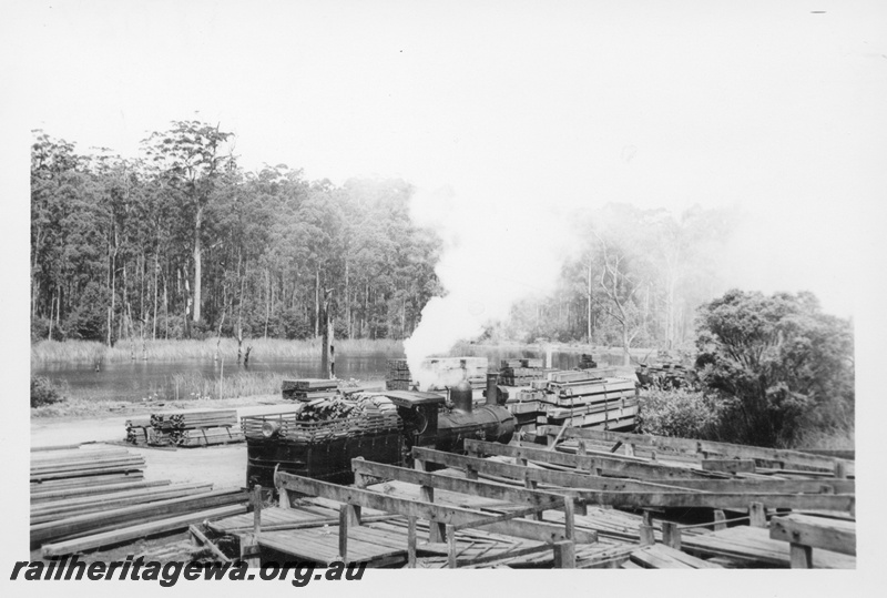 P17027
State Saw Mill No 2 G class loco, shunting timber wagon, timber piles, lake and forest in background, Deanmill, Deanmill to Manjimup branch 
