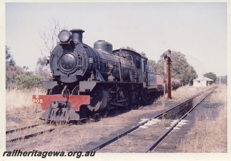 P17055
W class 905 at the head of a goods train, Bowelling, BN line, Note the water column and ash pit to the left of the locomotive. Sand on the track assists the locomotives when starting on a wet rail.
