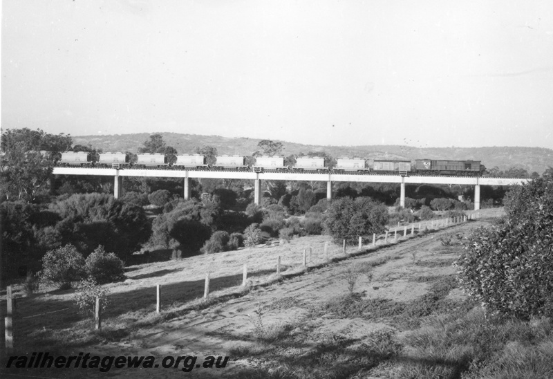 P17083
RA class 1906 diesel locomotive hauling 15 XE class Ilmenite hoppers on the Upper Swan bridge. MR line.
