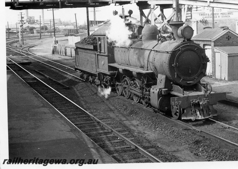 P17126
F class 457 locomotive front and side view at East Perth, now Claisebrook. Note overhead line. footbridge & track workers sheds to the left of loco. East Perth Power House in background. SWR 
