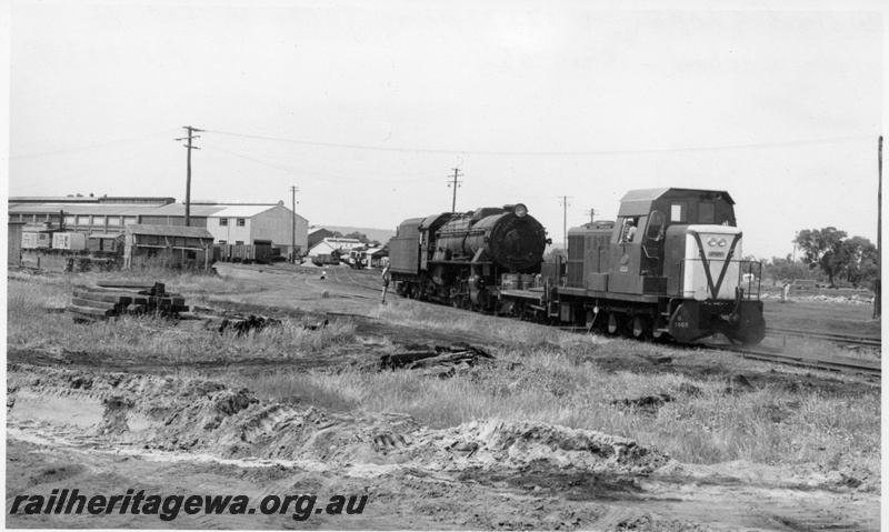 P17130
V class 1222 being shunted by B class 1608 diesel hydraulic shunter at Midland Workshops. The V class was to receive an A grade overhaul. Note sleeper stack to left foreground of locos and Workshops buildings in background. ER line.
