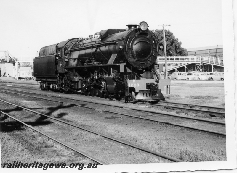 P17145
V class 1203 steam locomotive pictured in Midland Yard after receiving an overhaul. Workshop building can be seen to right and footbridge in background. ER line.
