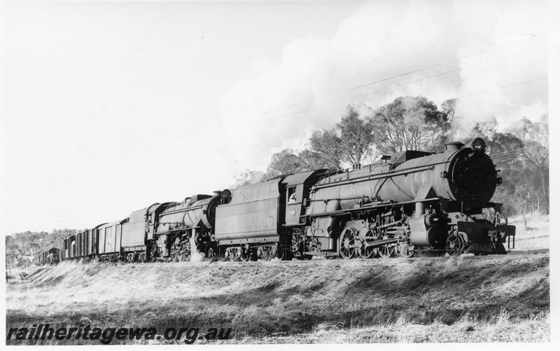 P17244
V class 1218 double heading with V class 1219 steam locomotives on goods train, side and front view, going up Cuballing bank, GSR line.
