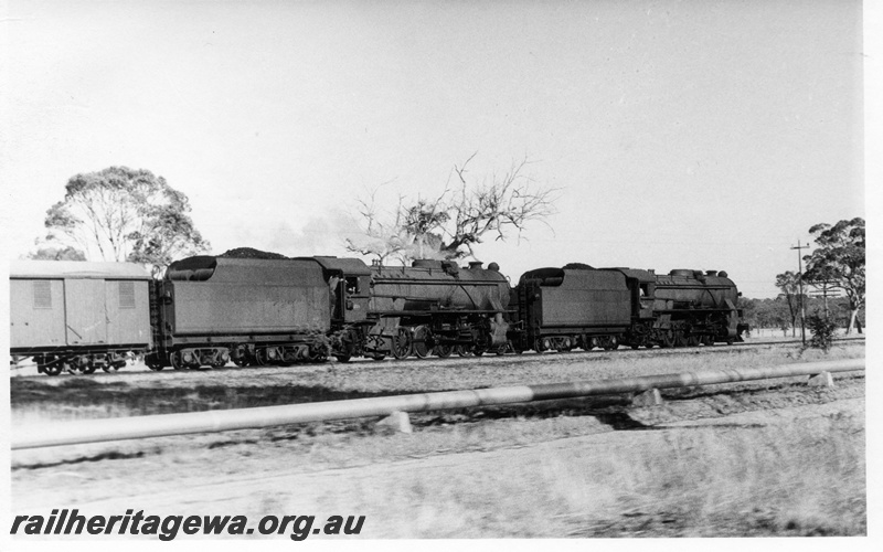 P17251
1 of 2, Two V class steam locomotives double heading on a goods train, side view, country location.
