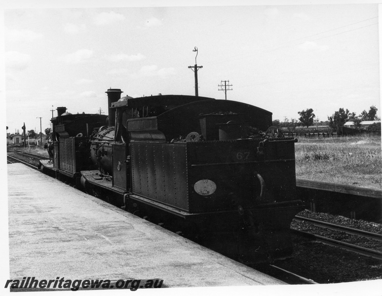 P17257
2 of 4, G class 118 steam locomotive double heading with G class 67 steam locomotive, running light engine, side view and end view, passenger platform, Pinjarra, SWR line.
