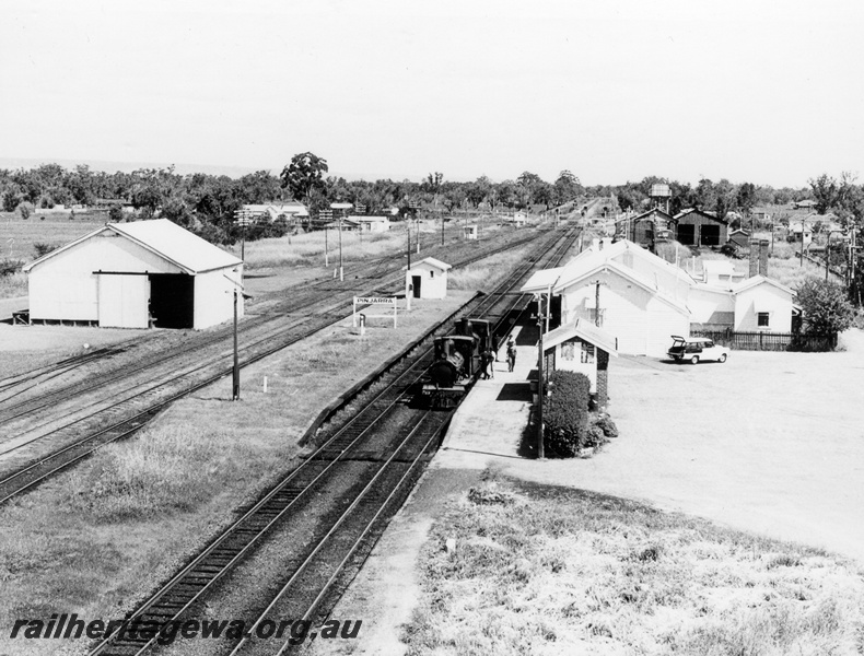 P17259
4 of 4, G class 118 steam locomotive double heading with G class 67 steam locomotive, elevated view of yard and locos, nameboard, station building, passenger platform, goods shed, loco shed, carriage shed, water tower, searchlight signals, sidings, Pinjarra, SWR line. 
