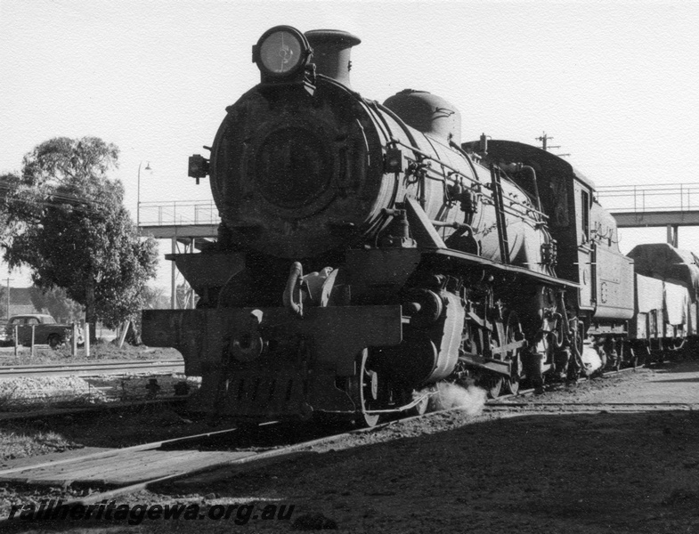 P17300
W class 937 steam locomotive, front and side view, passing under the footbridge at Merredin, EGR line.
