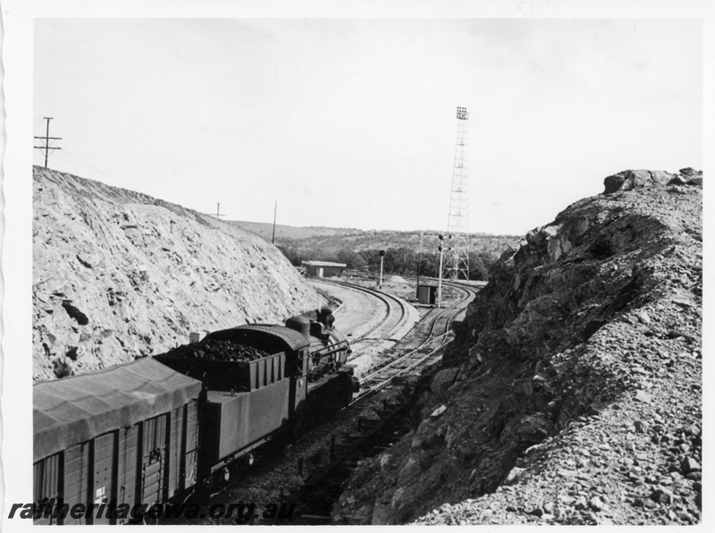 P17310
An unidentified PM class locomotive arriving Avon Yard, having just crossed the standard gauge line. Note the light tower in the background and staff working sheds in background. ER Line. 
