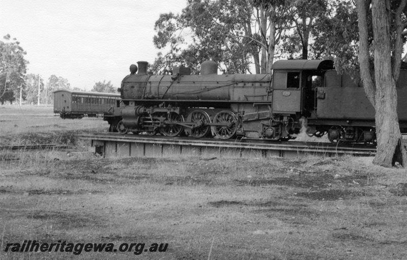 P17324
PMR class 730 locomotive on turntable at Chidlow. Side view of locomotive/turntable and suburban side door carriages in background. Semaphore signals in distance. ER line.
