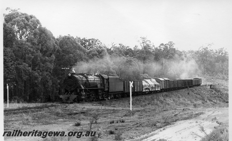 P17325
V class 1221 steam locomotive, front and side view, on goods train, going through a level crossing, Moorhead, BN line.
