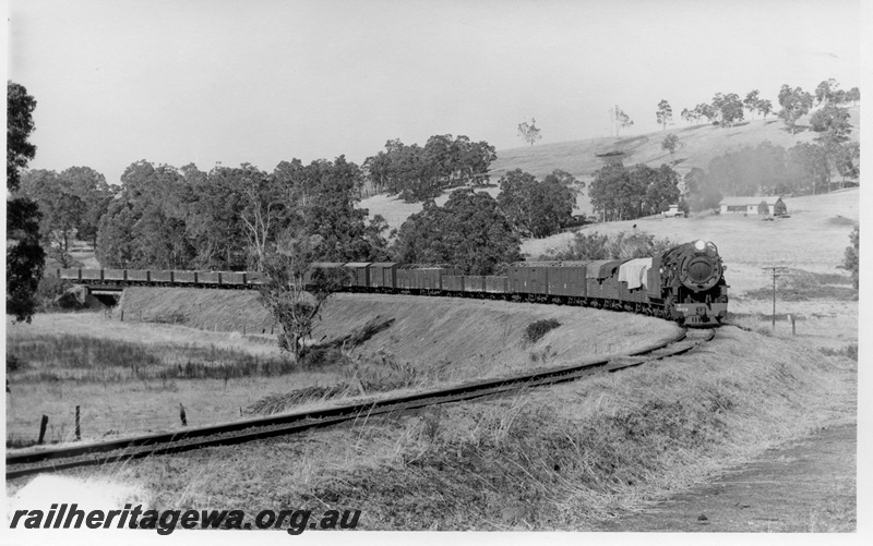 P17335
V class 1203 steam locomotive, on goods train, crossing bridge on sweeping curve, side and front view, BN line.
