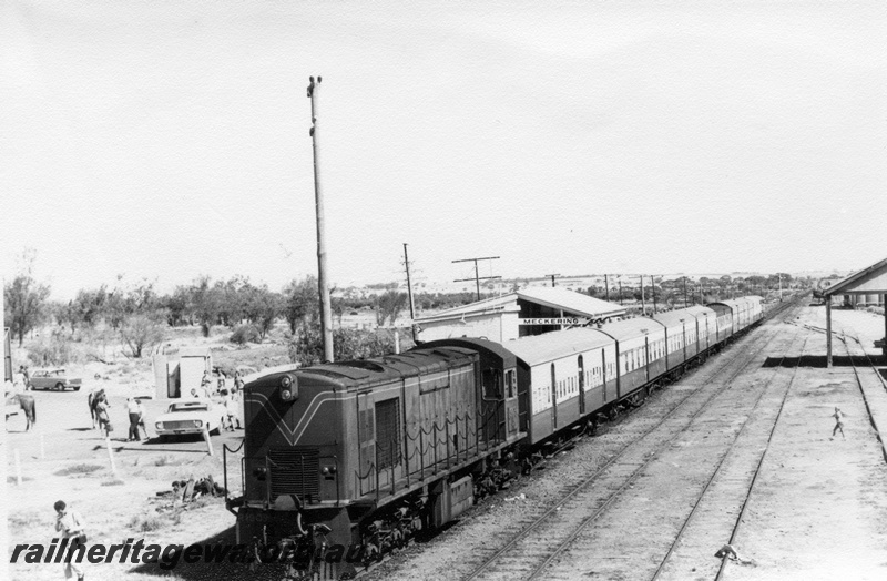 P17580
2 of 4, R class 1903 diesel locomotive on ARHS tour train to Meckering, running long end first, station building, out-of shed, goods shed, wheat bin in the background, scotch block, sidings and tracks, Meckering, EGR line.
