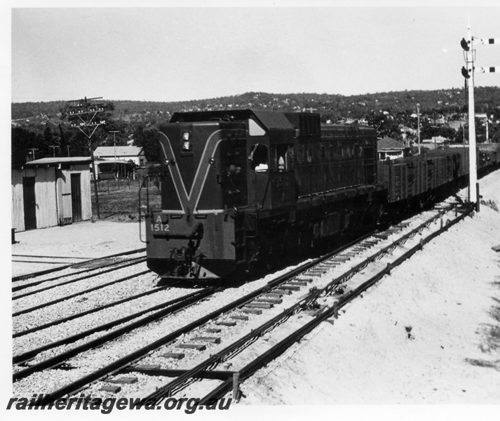 P17592
A class 1512 diesel locomotive hauling a goods train into the yard at the eastern end of Midland. Front & side view of locomotive, signal wiring and points rods also visible.ER line.
