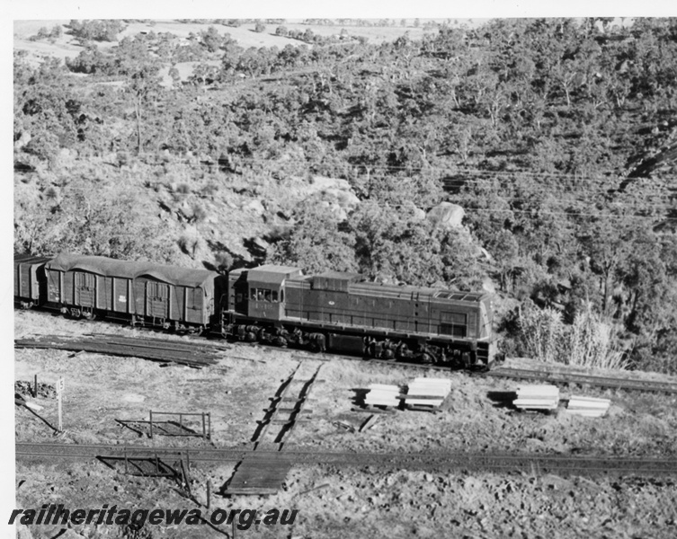 P17594
An unidentified A class diesel locomotive hauling a goods train exiting the Tunnel Bypass in the Darling Ranges. ER line. Note the cross rail for track gang vehicles to change direction.
