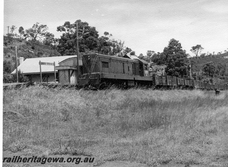 P17613
A class 1502 diesel locomotive hauling a goods train at Swan View. ER line. Note the nameboard and station building on platform.
