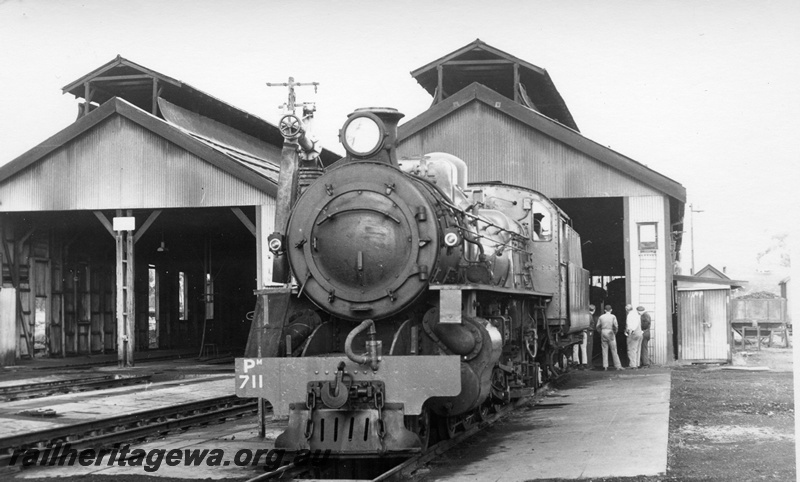 P17741
PM class 711 steam locomotive outside the former Northam Steam Loco Depot. ER line. Tradesmen looking at interior of depot. Locomotive is still operational.
