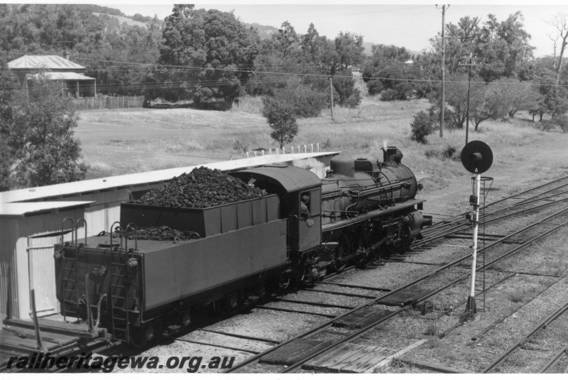 P17758
PMR class 730 steam locomotive hauling 35 Goods leaving Mundijong for Bunbury. SWR line. Automatic signal to right of locomotive and gangers shed and signalling room to left.
